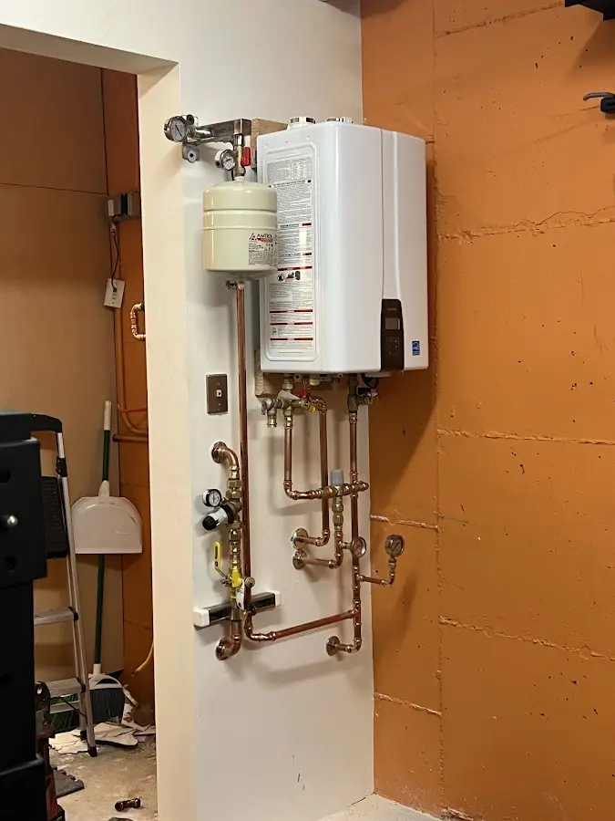 Plumbing technician inspecting water heater connections in Roseville